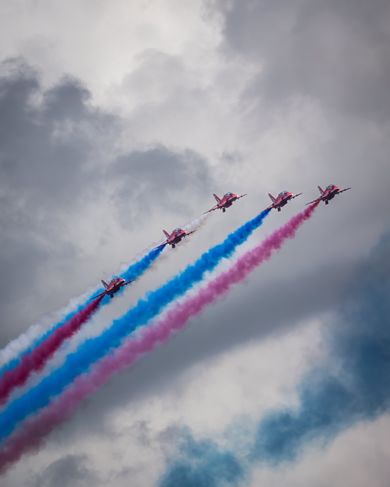 Aviones sobrevuelan el circuito de Silverstone soltando humo rojo, blanco y azul