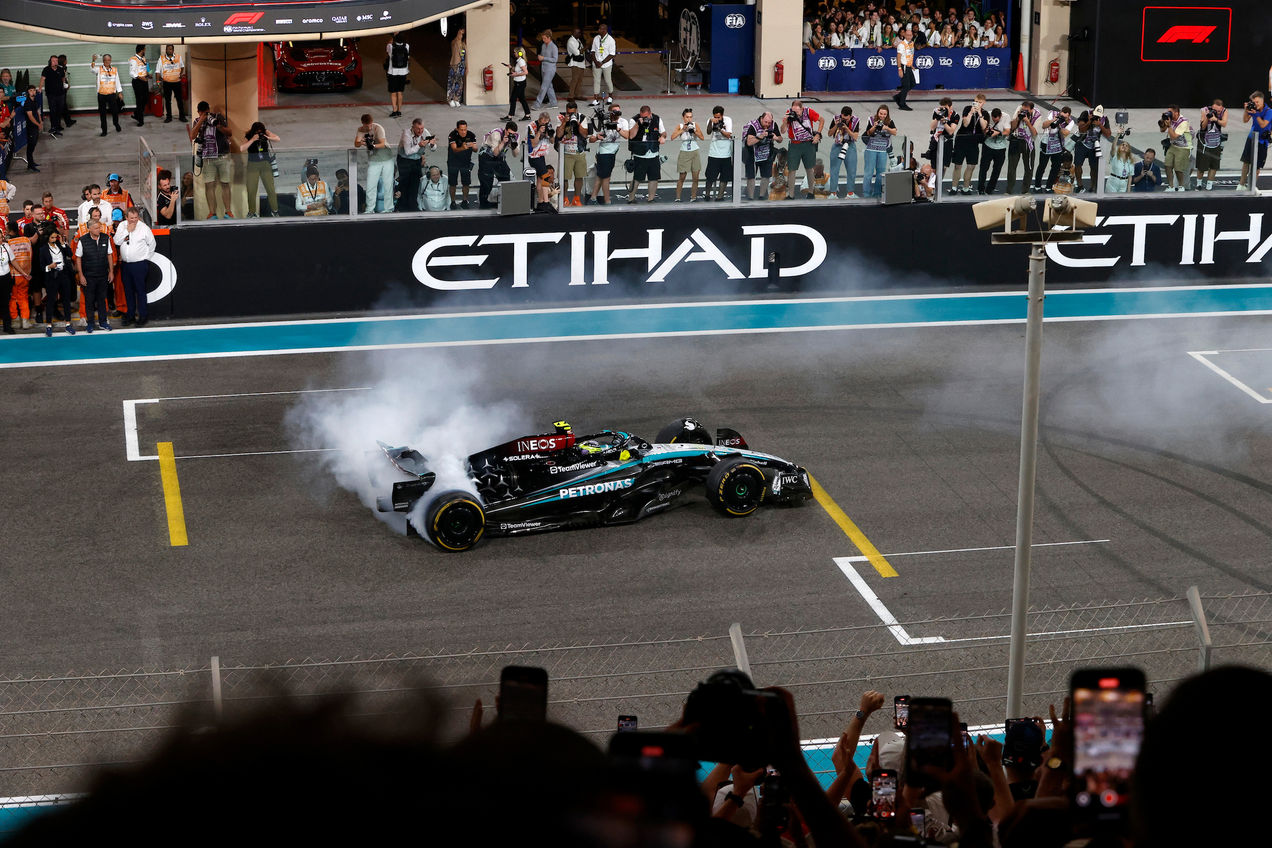 A Mercedes F1 car doing tricks on the Main Straight of Yas Marina Circuit