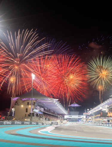 The Main Straight of Yas Marina Circuit with fireworks going off in the background