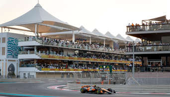 A McLaren car taking on the first corner of Yas Marina Circuit