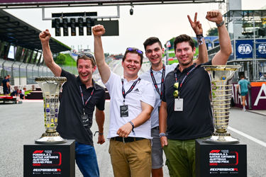 Een groep gasten van F1 Experiences poseert voor de kampioenschapstrofee