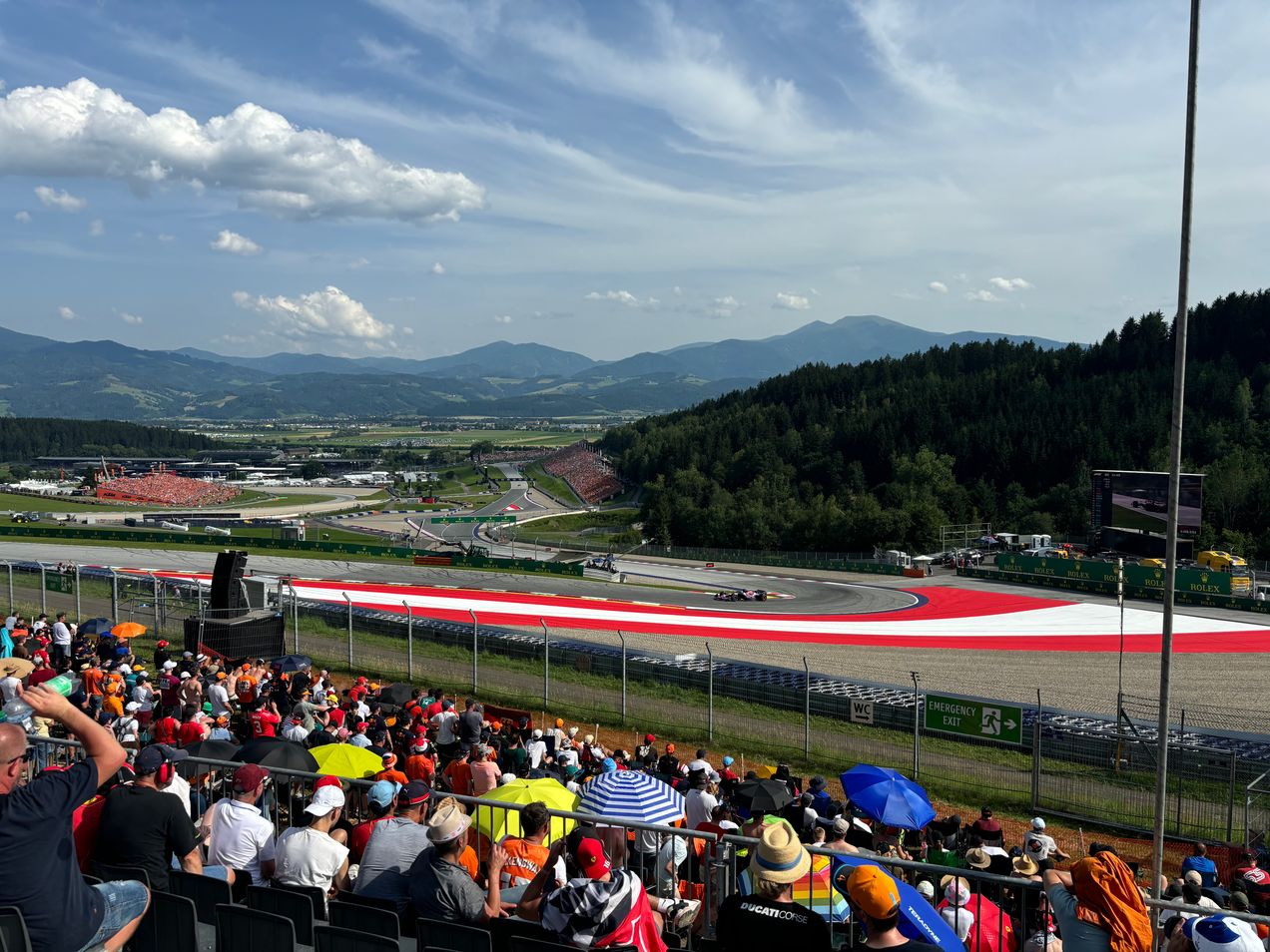 Fans on Grandstand T3 on the Red Bull Ring watching the drivers take on corner 3