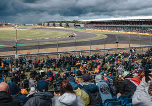 An F1 car in the Chapel-corner while fans are watching from the grandstand