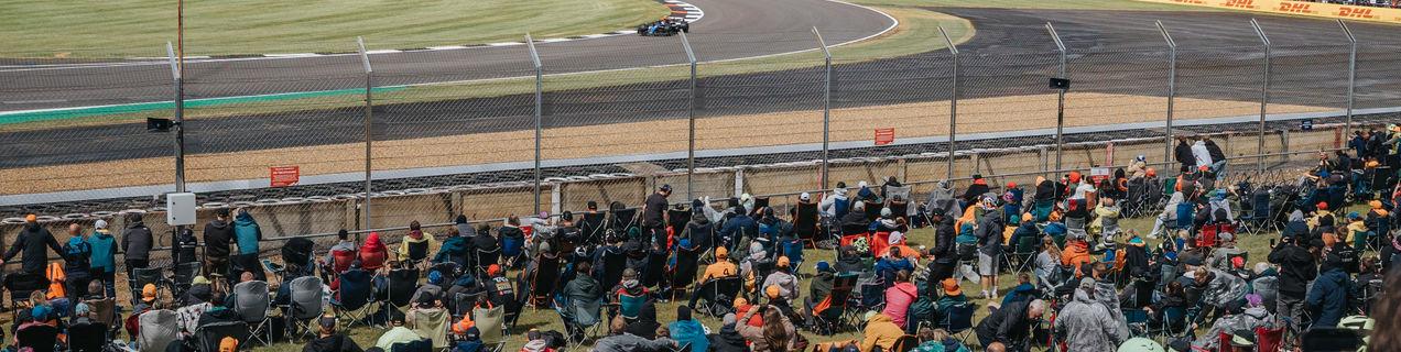An F1 car in the Chapel-corner while fans are watching from the grandstand