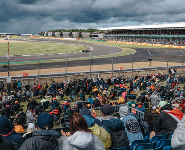 An F1 car in the Chapel-corner while fans are watching from the grandstand