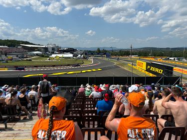 Fans op de Red Bull tribune op de Hungaroring zien de F1 auto's voorbij rijden