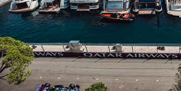 Alpine F1 car driving past the yachts in the harbor of Monaco