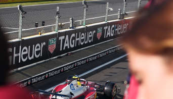 Ferrari car leaving the pit lane with the main grandstand in the background