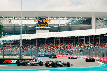 Les voitures de F1 courent sur le circuit de Miami avec le Hard Rock Stadium en arrière-plan