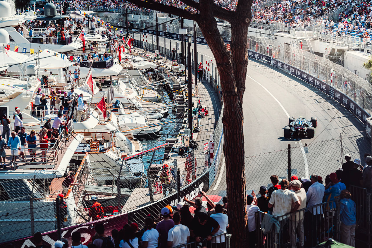 Espectadores en un yate ven un Alpine F1 corriendo por el puerto de Mónaco
