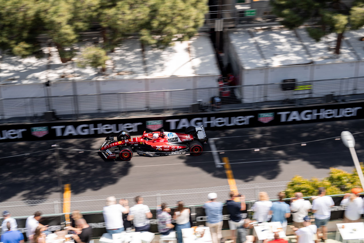 A Ferrari F1 car driving past the Corner33 terrace
