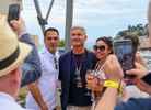 Two St Devote Hospitality guests taking a picture with former F1 driver David Coulthard