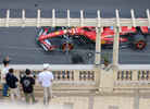 A Ferrari race car driving closely past the terrace of the St Devote Hospitality venue in Monaco