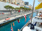 Racing cars driving past the yachts moored at the Monaco GP