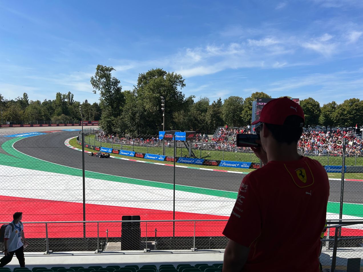 Een Ferrari-fan die een F1-auto filmt die langs tribune 22 op het circuit van Monza rijdt