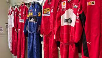 Old Ferrari racing suits displayed in the SGP Club hospitality area