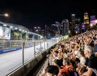 La tribune Connaught bondée de fans de F1, avec la silhouette de Singapour en arrière-plan