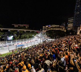 Fans auf der Empress Grandstand beobachten die vorbeifahrenden F1-Autos beim Grand Prix von Singapur
