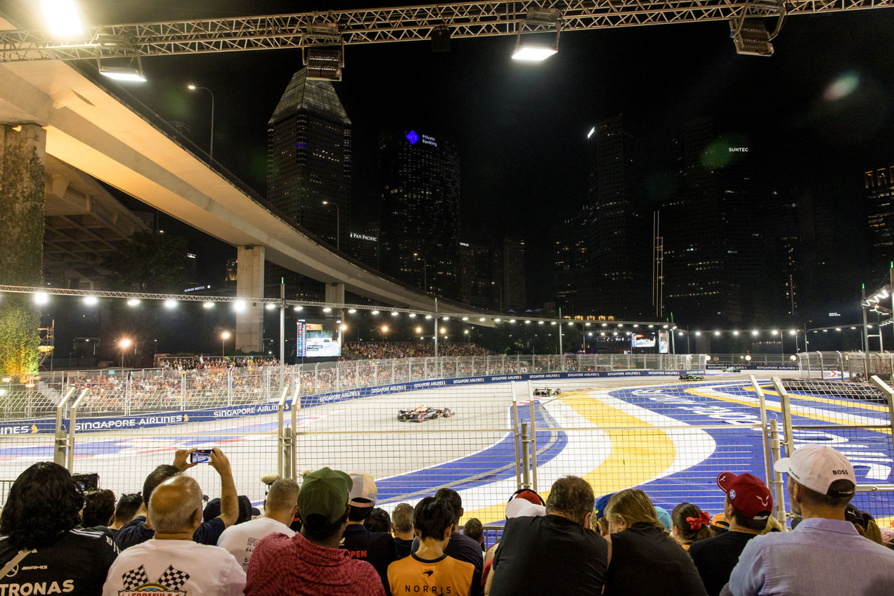 Vanaf de tribune bij bocht 1 zie je hoe de auto's zich voorbereiden op de tweede bocht van het circuit