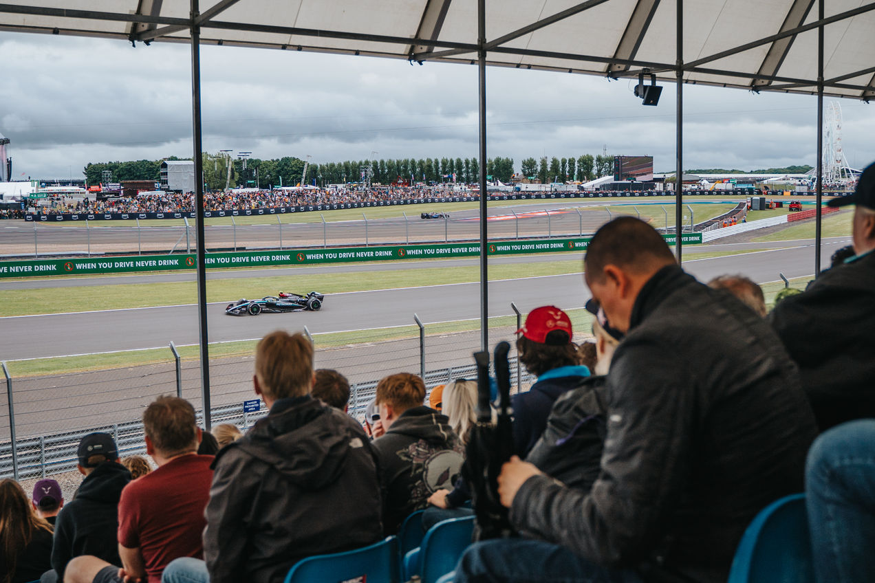 Fans on Woodcote grandstand watching the F1 cars race past