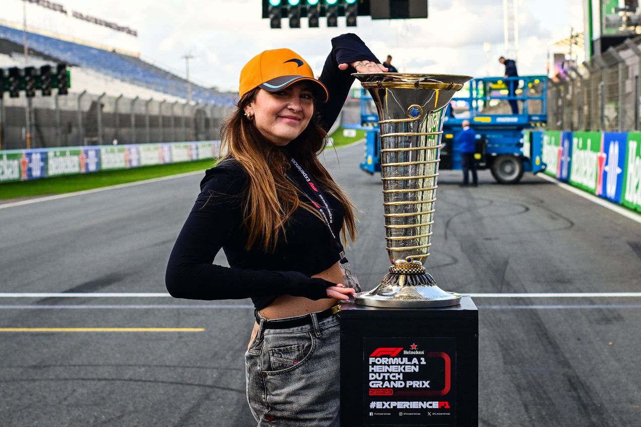 A young woman poses with the F1 Championship Trophy at the Dutch GP