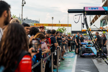 Formule 1-fans bekijken een demonstratie van een Formule 1-racewagen tijdens een pitstraatwandeling