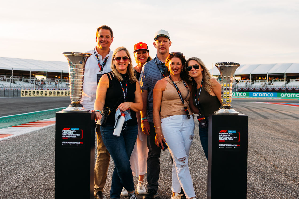 A group of f1 fans pose for a photo with the Championship trophy at the Spanish GP