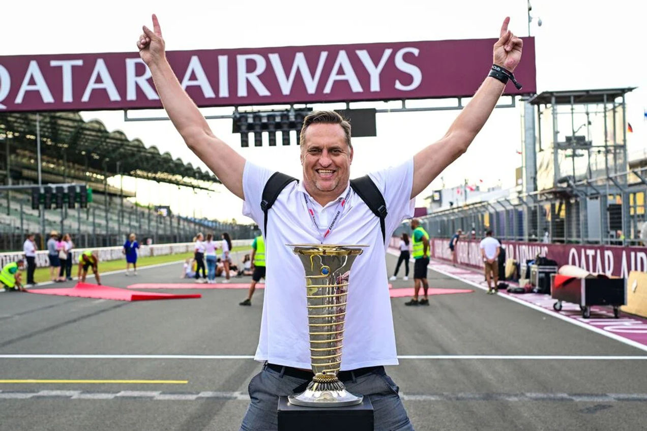 An F1 fan poses with the F1 championship trophy photo