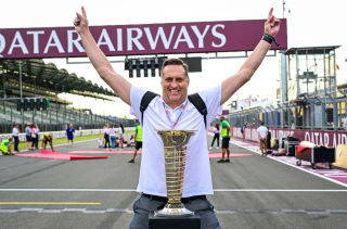 An F1 fan poses with the F1 championship trophy photo