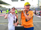 Dos aficionados posan con el trofeo del campeonato de F1