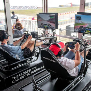 Gasten van de Champions Club rijden in racesimulators in de lounge