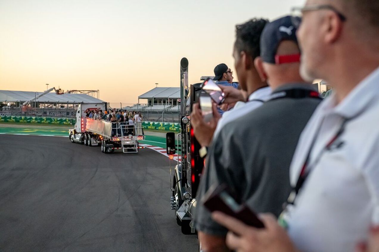 F1-fans genieten van een rondleiding op het Circuit of the Americas achterop een dieplader