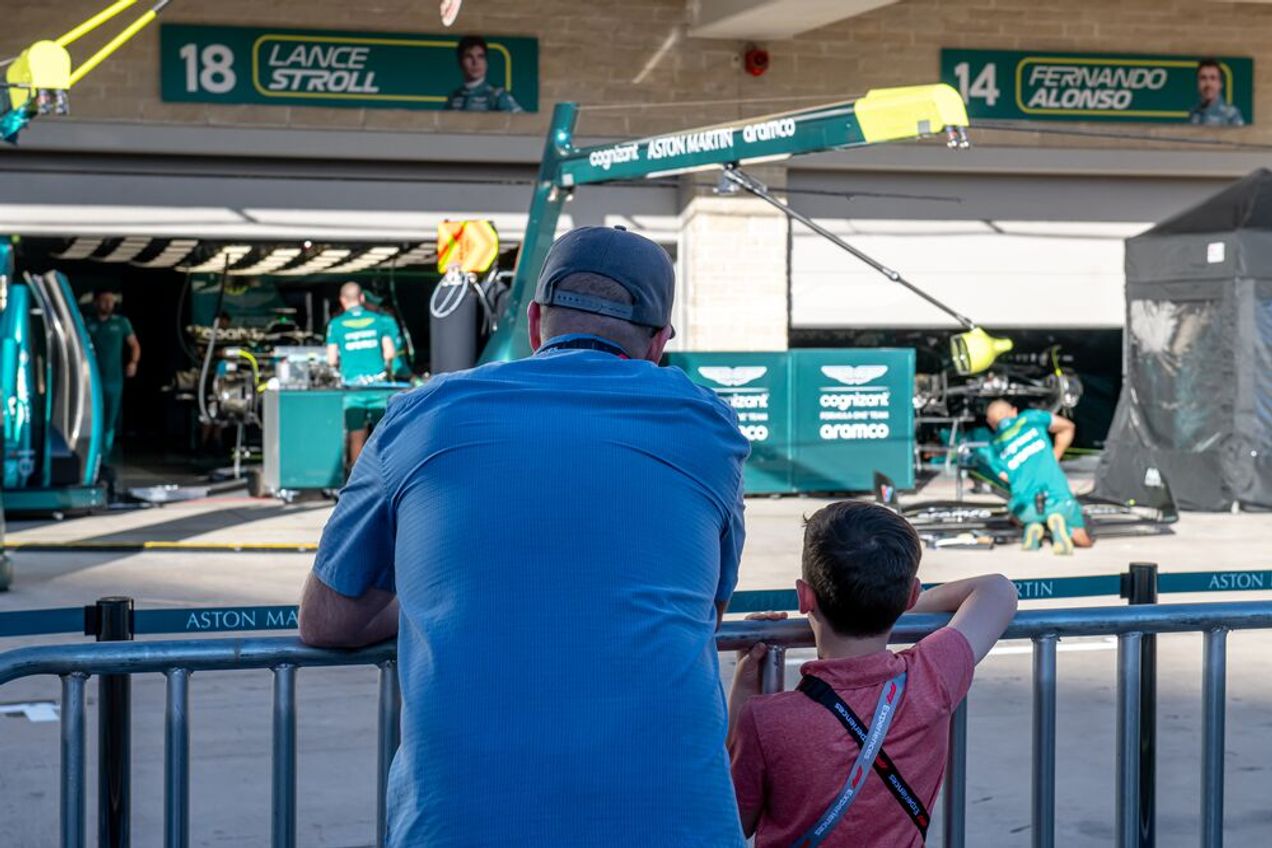 F1 fans watch the teams perform a pit lane stop during a pit lane walk