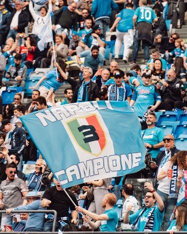 SSC Napoli supporter waving a club flag in the stands at Stadio Diego Armando Maradona