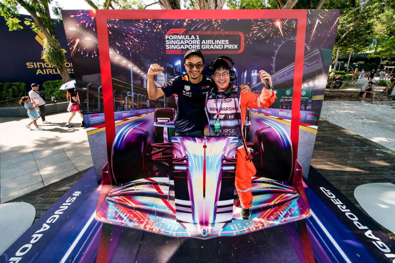 F1 fan poses for a photo at the Singapore with a racing car