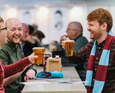 Aficionados del West Ham United disfrutando de bebidas en una sala de hospitality en el London Stadium