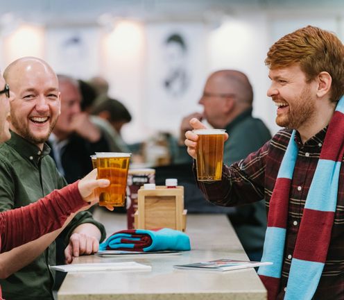 West Ham United fans enjoying drinks in a hospitality lounge at London Stadium