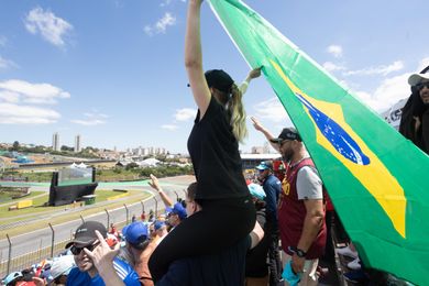 F1 fans carrying a Brazilian flag cheer on the drivers at the Brazilian GP